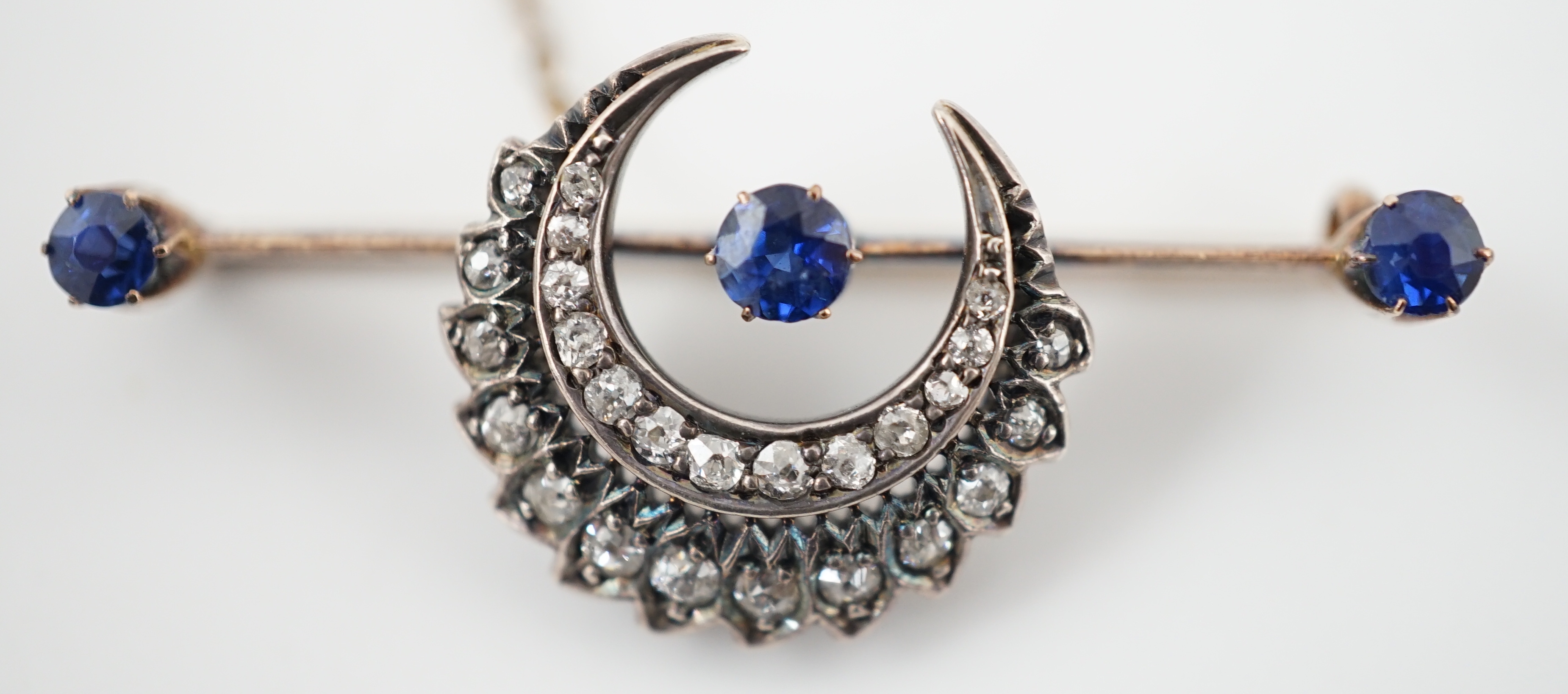 A Victorian gold and silver, three stone sapphire and diamond cluster set double crescent bar brooch